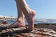 Piedi nudi sul tronco in spiaggia
